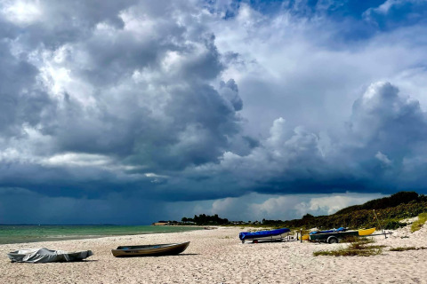 Strand mit Booten und dramatischen Wolken beim 8-Personen-Ferienhaus in Sydals, Dänemark.