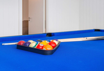 Table de billard bleue avec des boules et des queues dans une maison de vacances à Sydals, Danemark.