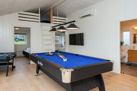 Salle de jeux avec table de billard, baby-foot, mezzanine et salle de bain d’un gîte pour 8 à Sydals, Danemark.