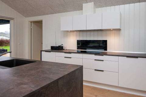 Modern kitchen in an 8-person holiday home in Sydals, Denmark, featuring white cabinets and dark counters.