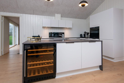 Modern keukeninterieur in een vakantiehuis in Sydals, Denemarken, met wijnkast en oven.