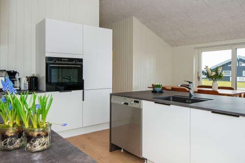 Moderne køkken på 8-personers feriehus i Sydals, Danmark, med hvide skabe og stor ø.
