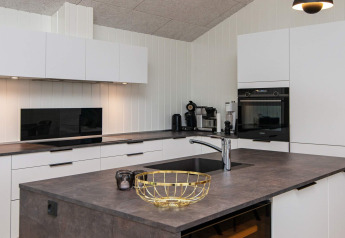 Cuisine moderne dans une maison de vacances pour 8 personnes à Sydals, Danemark, avec îlot central et équipements intégrés.