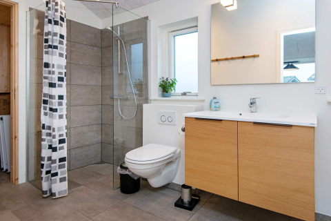 Moderne badkamer in vakantiehuisje voor 8 personen in Sydals, Denemarken, met glazen douche en zwevend toilet.