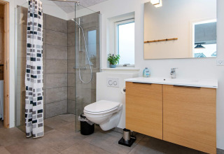 Baño moderno en casa de vacaciones para 8 personas en Sydals, Dinamarca, con ducha de vidrio y mueble lavabo.