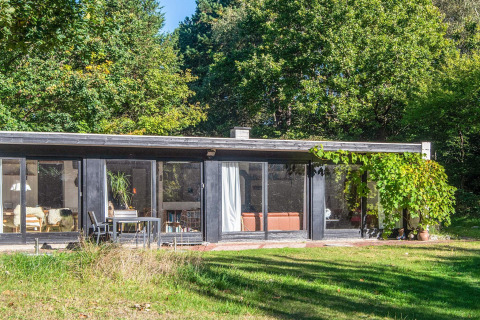 Modern vakantiehuis in Ebeltoft, Denemarken, met grote ramen, terras en groene tuin rondom.