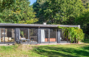 Casa vacacional moderna en Ebeltoft, Dinamarca, con amplios ventanales y jardín verde alrededor.