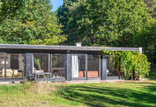 Maison de vacances moderne à Ebeltoft, Danemark, avec grandes baies vitrées et jardin verdoyant.