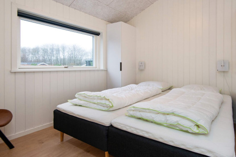 Bedroom with two single beds, large window, and wardrobe in holiday home in Sydals, Denmark.
