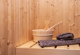 Sauna in legno con secchio e asciugamani grigi su panca nel ‘8 person holiday home in Sydals’, Danimarca.
