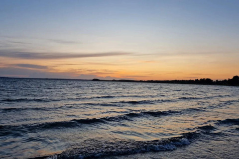 Coucher de soleil sur les vagues près de la plage à la cabane ‘4 person holiday home in Knebel’, Danemark.