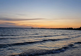 Tramonto sulle onde viste dalla riva presso la cabina ‘4 person holiday home in Knebel’ in Danimarca.