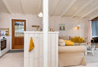 Intérieur lumineux d'un chalet de vacances à Knebel, Danemark, avec cuisine ouverte et salon confortable.