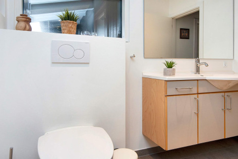 Moderne badkamer met toilet en lavabo in een vierpersoons vakantiewoning in Knebel, Denemarken.