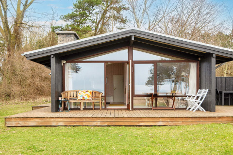Charmante maison de vacances pour 4 personnes à Knebel, Danemark, grande terrasse en bois et meubles de jardin.