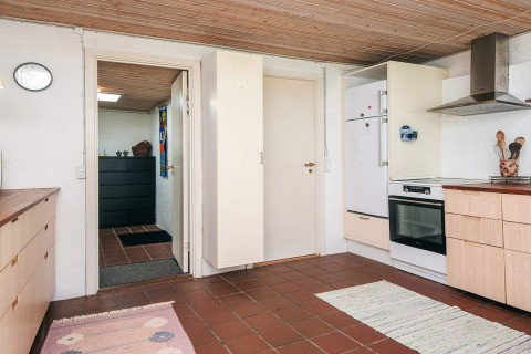 Keuken in een vakantiehuis in Ebeltoft, Denemarken, met een betegelde vloer en een houten plafond.
