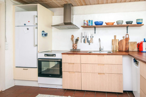 Moderne keuken in vakantiehuis in Ebeltoft, Denemarken, met houten kasten en open plank.