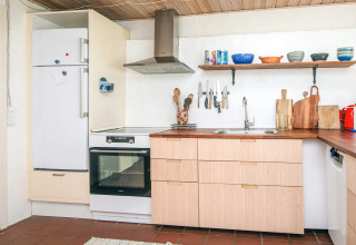 Moderne keuken in vakantiewoning in Ebeltoft, Denemarken, met houten meubels en open rekken.