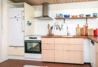 Moderne Küche im Ferienhaus in Ebeltoft, Dänemark, mit Holzarbeitsplatte und offenen Regalen.
