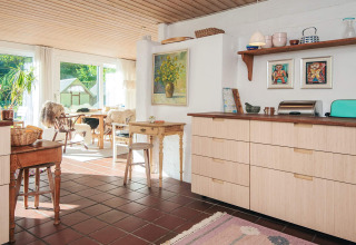 Cuisine lumineuse et salle à manger dans une maison de vacances à Ebeltoft au Danemark, décor chaleureuse.