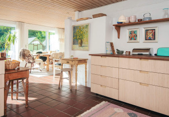 Cucina luminosa e zona pranzo in una casa vacanza a Ebeltoft, Danimarca, con arredi accoglienti.