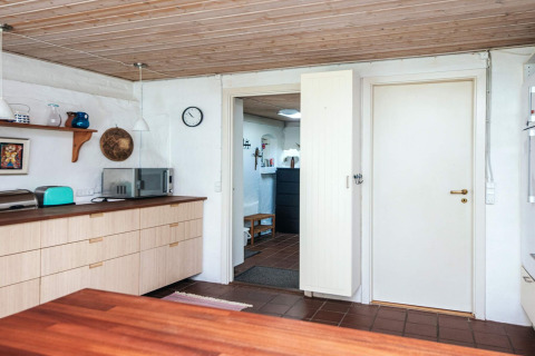 Cuisine moderne dans une maison de vacances à Ebeltoft, Danemark, avec plafond bois et micro-ondes.