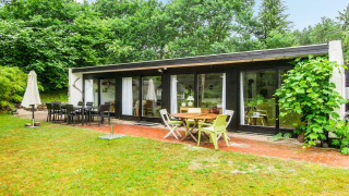 Buitenzicht van een vakantiehuis voor 6 personen in Ebeltoft met terras, tuinmeubels en veel groen.