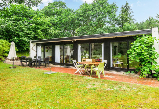 Buitenaanzicht van een 6-persoons vakantiehuis in Ebeltoft met terras, tuinset en groene omgeving.