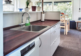 Modern kitchen of a 6-person holiday home in Glesborg, Denmark, featuring a dining area and dishwasher.