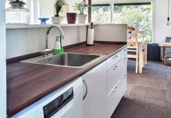 Cocina moderna en casa de vacaciones para 6 personas en Glesborg, Dinamarca, con lavavajillas y comedor.