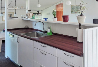 Cocina moderna en casa de vacaciones de 6 personas en Glesborg, Dinamarca, con fregadero y plantas.