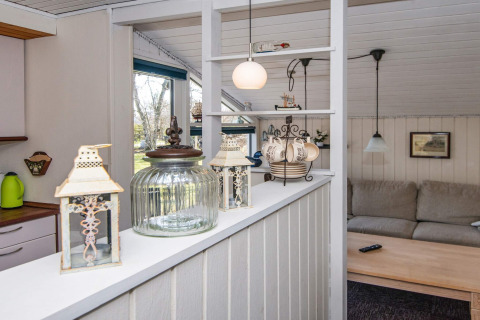 Living area and kitchen counter of a holiday home in Glesborg, Denmark, with lanterns and glass jar.