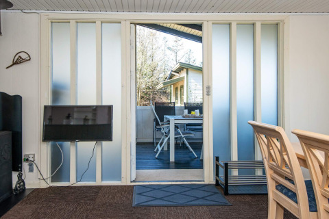 Woonkamer met terraszicht via schuifdeuren in 6-persoons vakantiehuis in Glesborg, Denemarken.