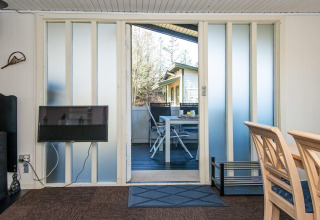 Woonkamer met terraszicht via schuifdeuren in 6-persoons vakantiehuis in Glesborg, Denemarken.