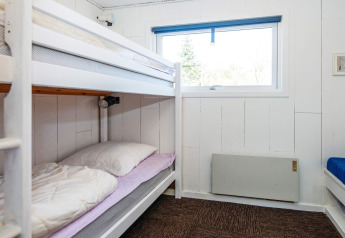 Habitación con literas y ventana en una casa de vacaciones para 6 personas en Glesborg, Dinamarca.