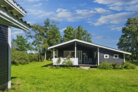Photo of a 6 person holiday home in Glesborg, Denmark with a veranda and lush green surroundings.