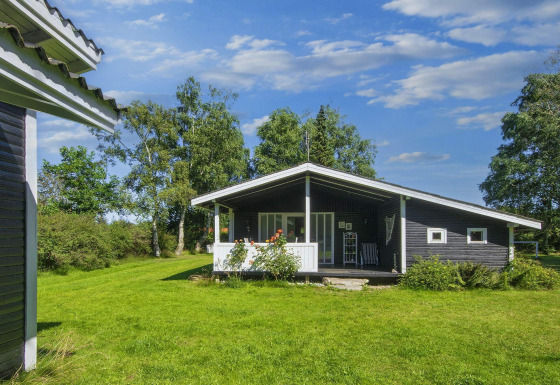 Photo of a 6 person holiday home in Glesborg, Denmark with a veranda and lush green surroundings.