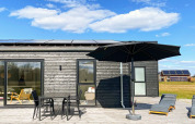 Terrasse du « gîte 8 personnes à Ansager », Danemark, avec mobilier d'extérieur, parasol et transats.