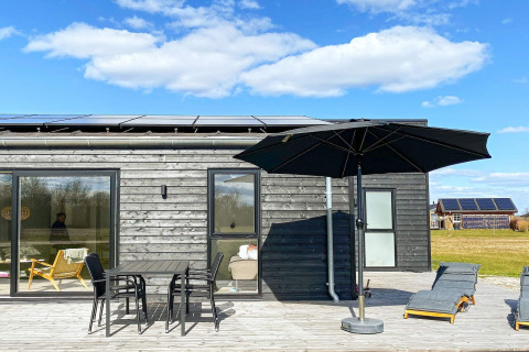 Terras bij het ‘8-persoons vakantiehuis in Ansager’, Denemarken, met tuinset, parasol en ligstoelen.