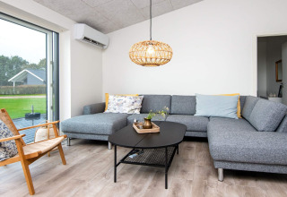 Moderne woonkamer in 8-persoons vakantiehuis in Ansager, Denemarken, met grijze zetel en grote ramen.