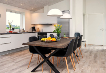 Cuisine et salle à manger modernes dans une maison de vacances à Ansager, Danemark, au décor épuré et chaleureux.