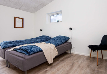 Chambre dans maison de vacances pour 8 personnes à Ansager, Danemark, avec deux lits simples et une chaise.