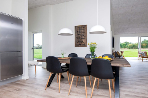Salle à manger moderne avec chaises noires et table en bois dans une maison de vacances à Ansager, Danemark.