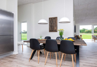 Eethoek met moderne stijl, zwarte stoelen en houten tafel in 8-persoons vakantiehuis te Ansager, Denemarken.