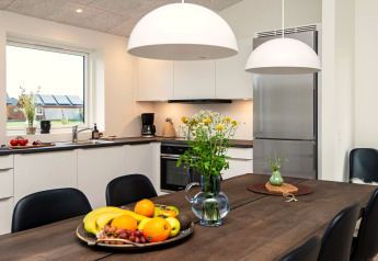 Cuisine moderne dans une maison de vacances à Ansager, Danemark, avec table, fruits et fleurs.