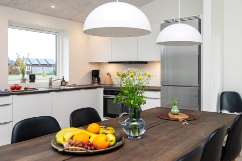 Moderne keuken in een vakantiehuis in Ansager, Denemarken, met eettafel, fruitschaal en bloemen.