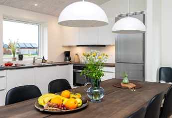 Cuisine moderne dans une maison de vacances à Ansager, Danemark, avec table, fruits et fleurs.