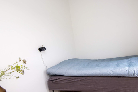 Camera essenziale nella casa vacanza per 8 persone ad Ansager, Danimarca, con letto e caricabatterie.