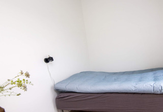 Ein schlichtes Schlafzimmer im 8-Personen-Ferienhaus in Ansager, Dänemark, mit Bett und Ladegerät.