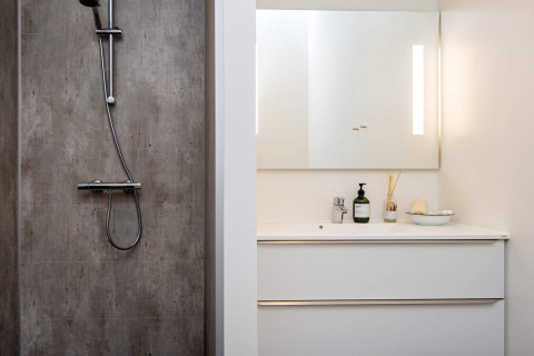 Moderne badkamer met douche, verlichte spiegel en witte wastafel in een 8-persoons vakantiehuis in Ansager.